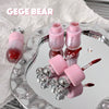 Pink nail polish bottles and accessories on a decorative tray with 'GEGE BEAR' branding.
