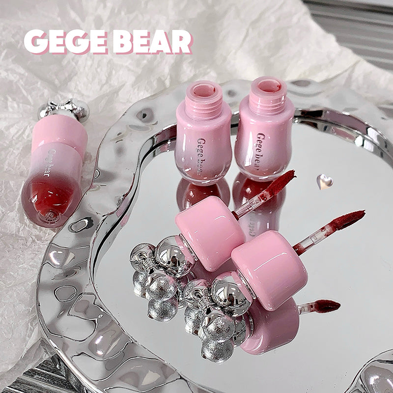 Pink nail polish bottles and accessories on a decorative tray with 'GEGE BEAR' branding.