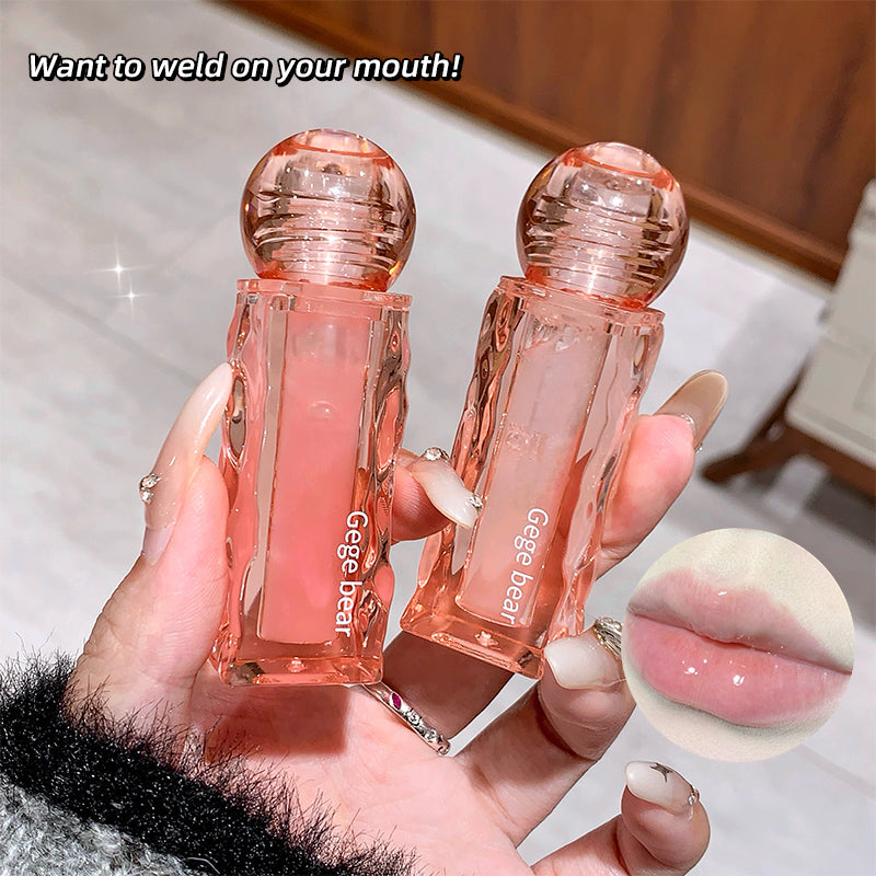 Two pink lip glosses held by a hand with an inset showing lips with gloss applied.