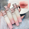 Set of pink and white gradient lip glosses with bear-shaped caps, held by a hand.