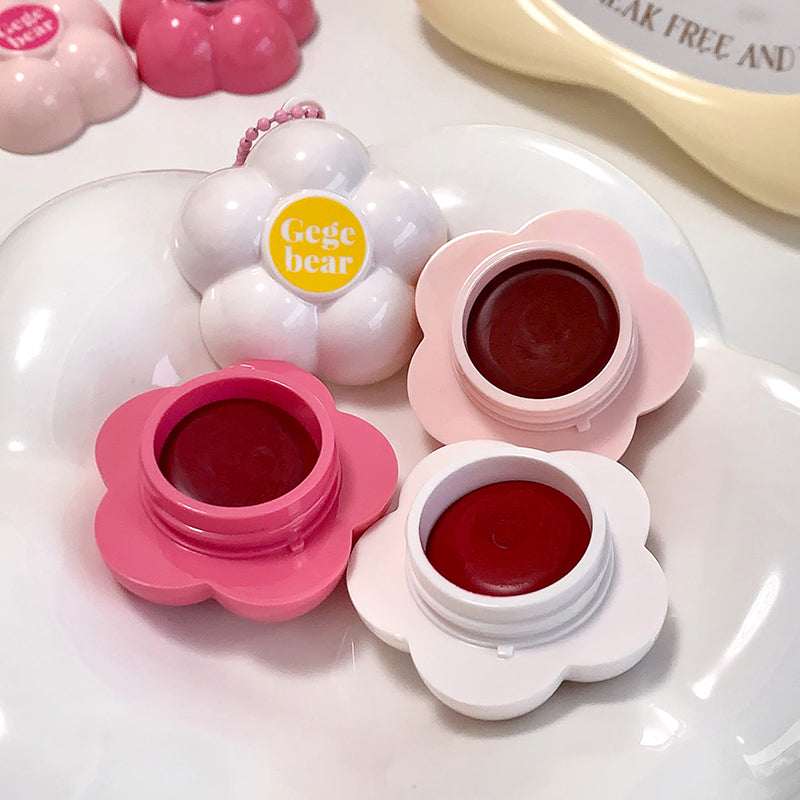 Flower-shaped lip balm with pink and white design on a white background
