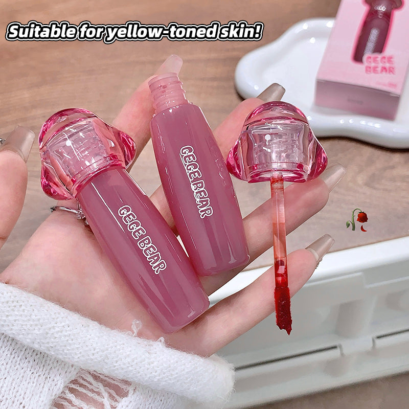 Pink lip gloss with clear cap held in a hand, brand 'Gee Bear' visible