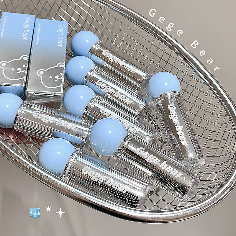 Clear lip gloss tubes with blue caps on a metal tray, branded 'Gege Bear'.