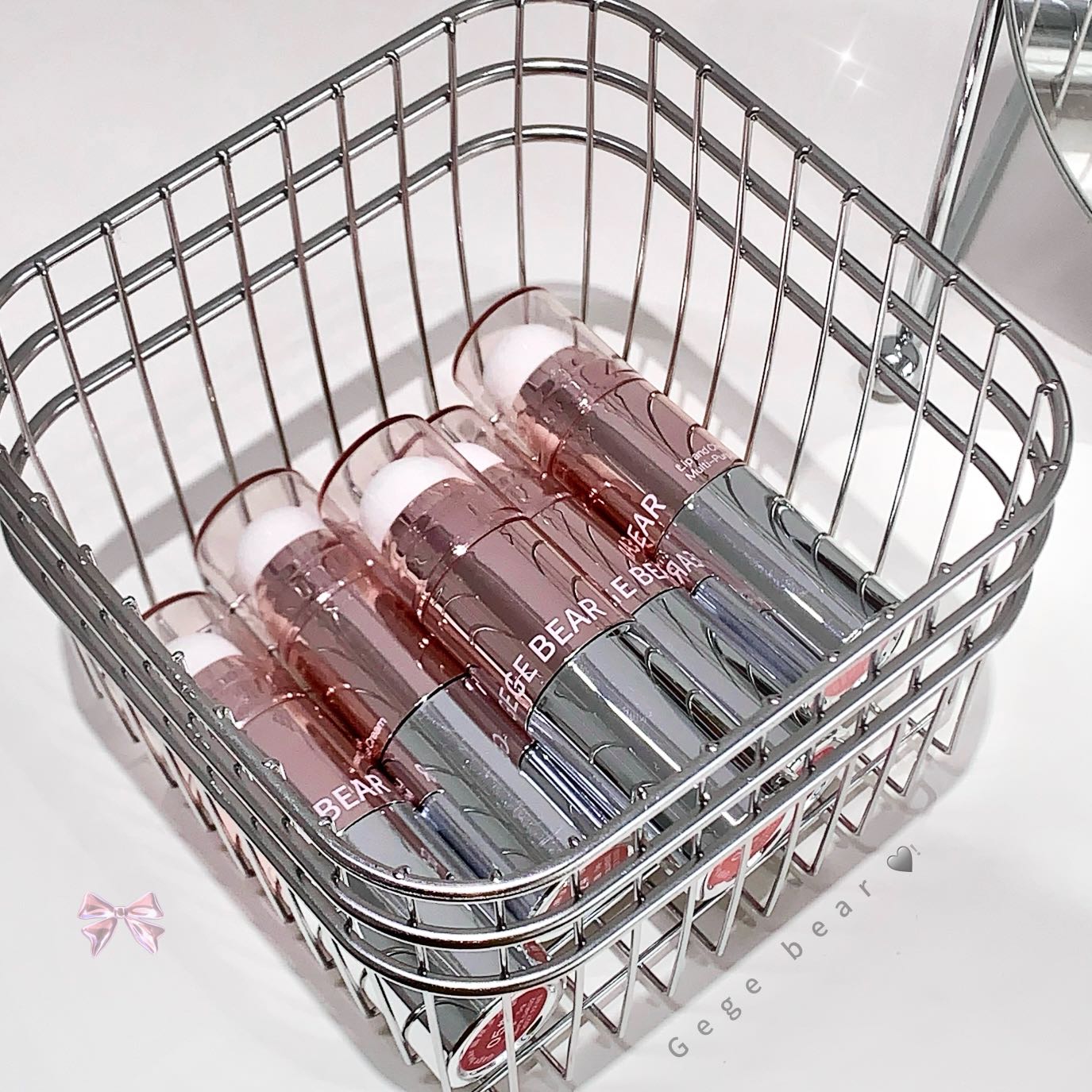 Metallic basket with lip gloss bottles labeled 'BEAR' on a white background