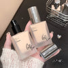 Two foundation bottles held by a hand with a blurred background
