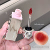 Lip gloss with applicator and texture sample held by a hand