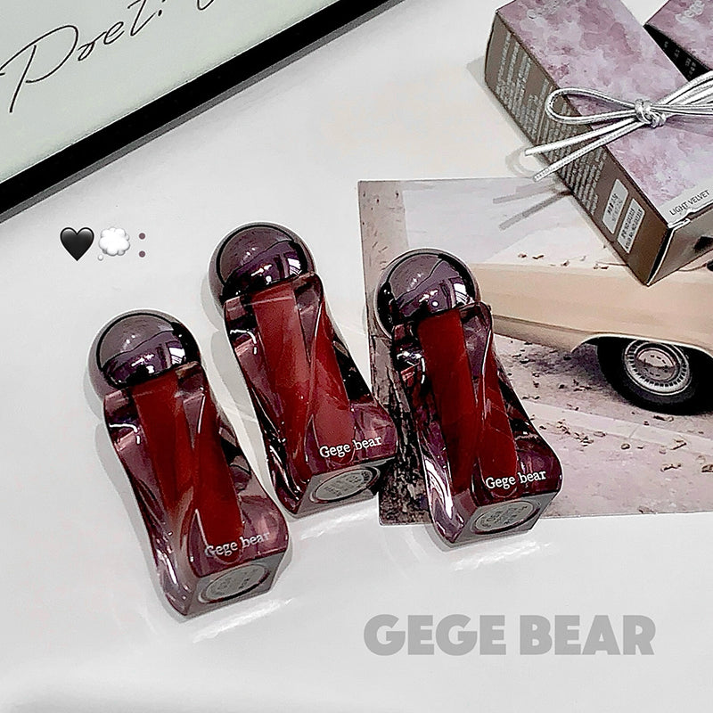 Three red bottles with purple caps labeled 'GEGE BEAR' on a white surface.
