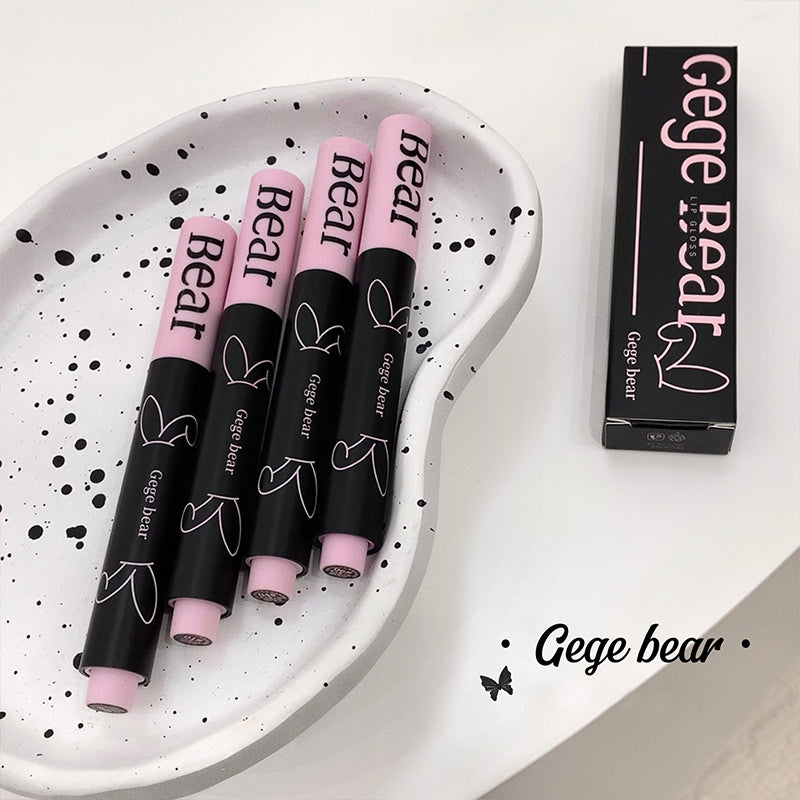 Four black and pink 'Gege bear' lip products on a white plate with packaging.