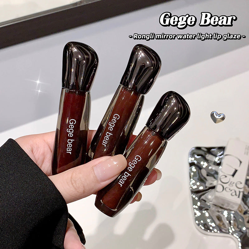Three Gege Bear lip glosses held in a hand with a blurred background