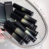 Black and green GEGE BEAR lip products on a metal grid surface.
