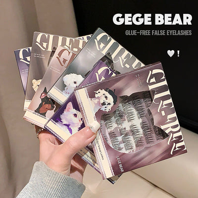 Hand holding GEGE BEAR glue-free false eyelashes packaging with brand name displayed.