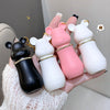 Five small animal-shaped bottles held in a hand against a neutral background
