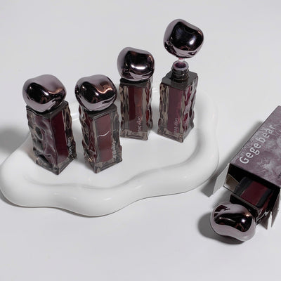 Set of nail polish bottles with metallic caps on a white stand, with 'Gege' branding visible.