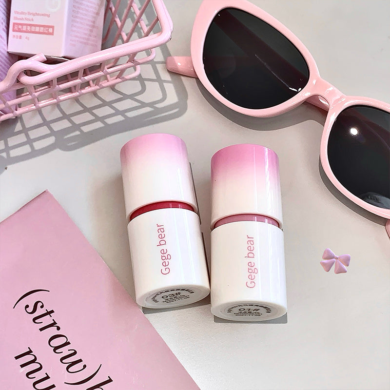 Two Gege bear lip products with pink sunglasses on a light surface.