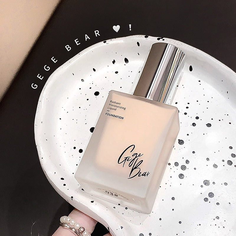 Foundation bottle with 'Gee Bear' branding on a speckled plate