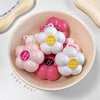 Pink and white flower-shaped products with 'Gege Bear' labels in a bowl.