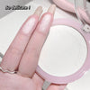 Hand holding a pink compact mirror with 'So delicate!' text above