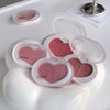 Heart-shaped blush compact with pink blush in multiple shades on a white surface.