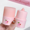 Two pink fruit extract lip balms with 'Gege bear' branding held by a hand.