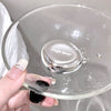Clear glass lid with 'Gege bear' branding held by a hand against a neutral background