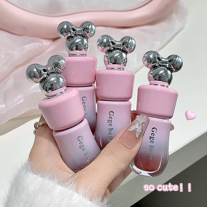 Pink bottles with silver tops held by a hand, labeled 'Gege bear', on a light pink background.