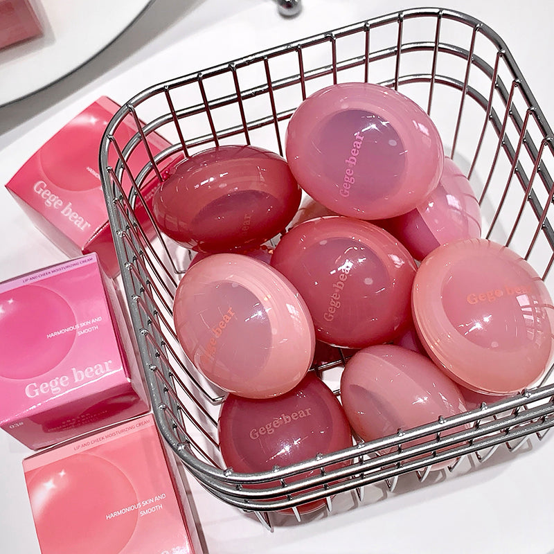 Pink spherical products with 'Gegé bear' branding in a metal basket on a white surface.