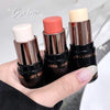 Three lipsticks held by a hand with a blurred background