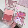 Pink blush compact with a cute character design on the case, held by a hand.