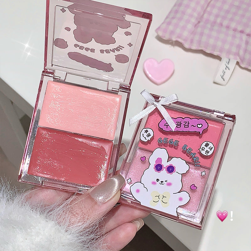Pink blush compact with a cute character design on the case, held by a hand.