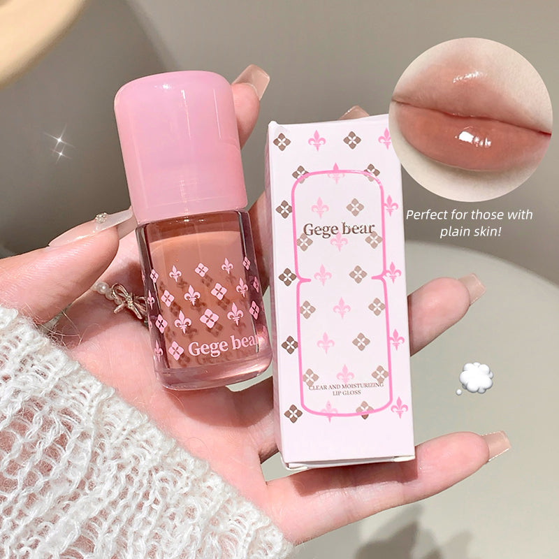 Lip gloss with pink cap and packaging held in hand, showing close-up of lip color.