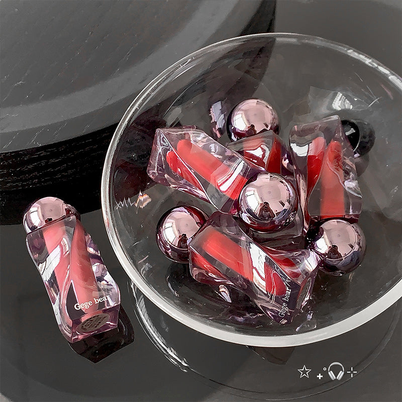 Pink and red gelatin cubes in clear packaging on a reflective surface