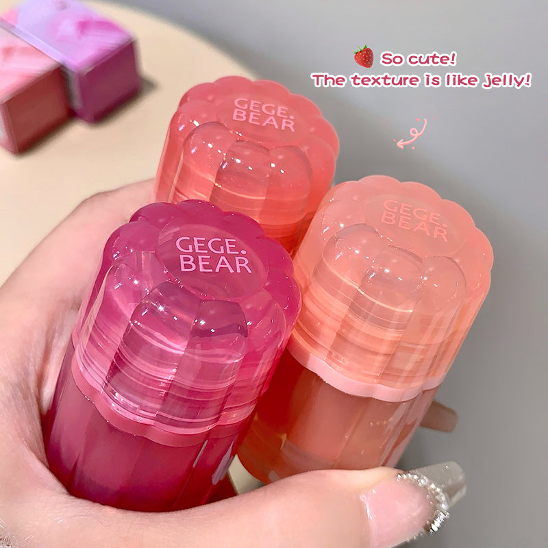 Hand holding pink and red GEGE BEAR products with text on a neutral background