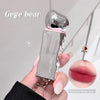 Clear lip gloss with pink cap held by a hand, 'Gege bear' branding visible.