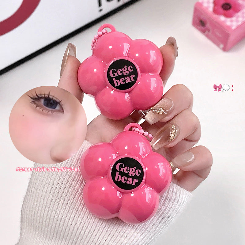 Pink flower-shaped hair tie with 'Gege bear' branding held by a hand.
