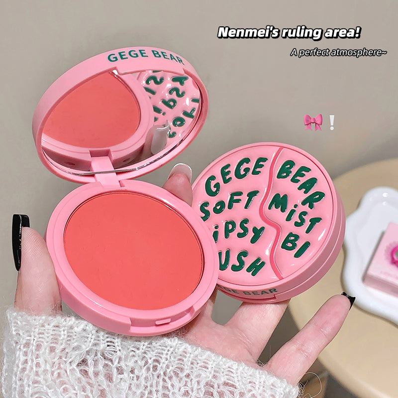 Pink makeup compact with 'GEGE BEAR' branding held by a hand.