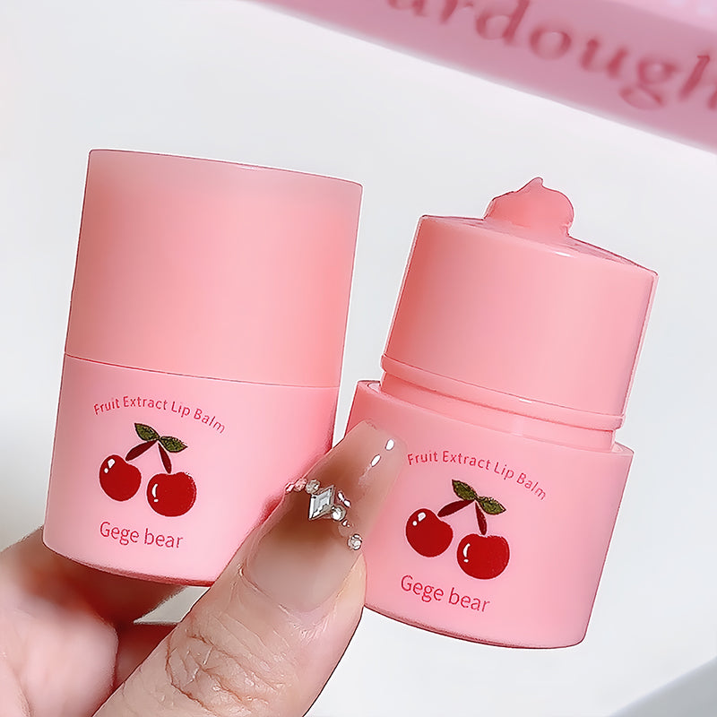 Two pink fruit extract lip balms with cherry design held by a hand against a white background.