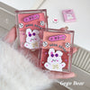 Two pink cases with a cartoon bear design held by a hand on a white background.