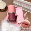 Hand holding a bottle of Gege bear Velvet Mist Lip and Cheek Multi-Purpose Cream with a pink packaging.