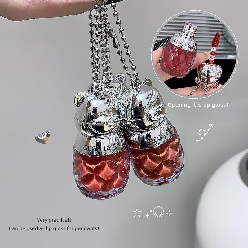 Two silver cat-shaped lip gloss pendants with red contents on a gray background.