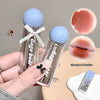 Two clear lip glosses with blue caps held by a hand, surrounded by close-up images of lips and a product box.