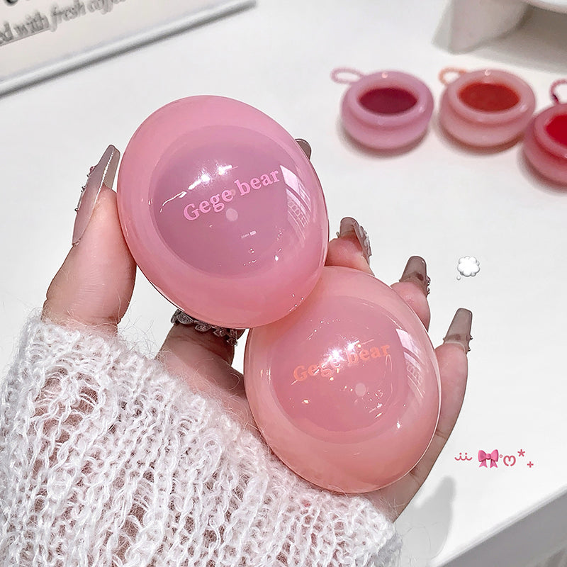 Pink lip balm with 'Gege bear' branding held by a hand against a white background.