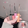 Set of makeup brushes with handles in various colors held by a hand.