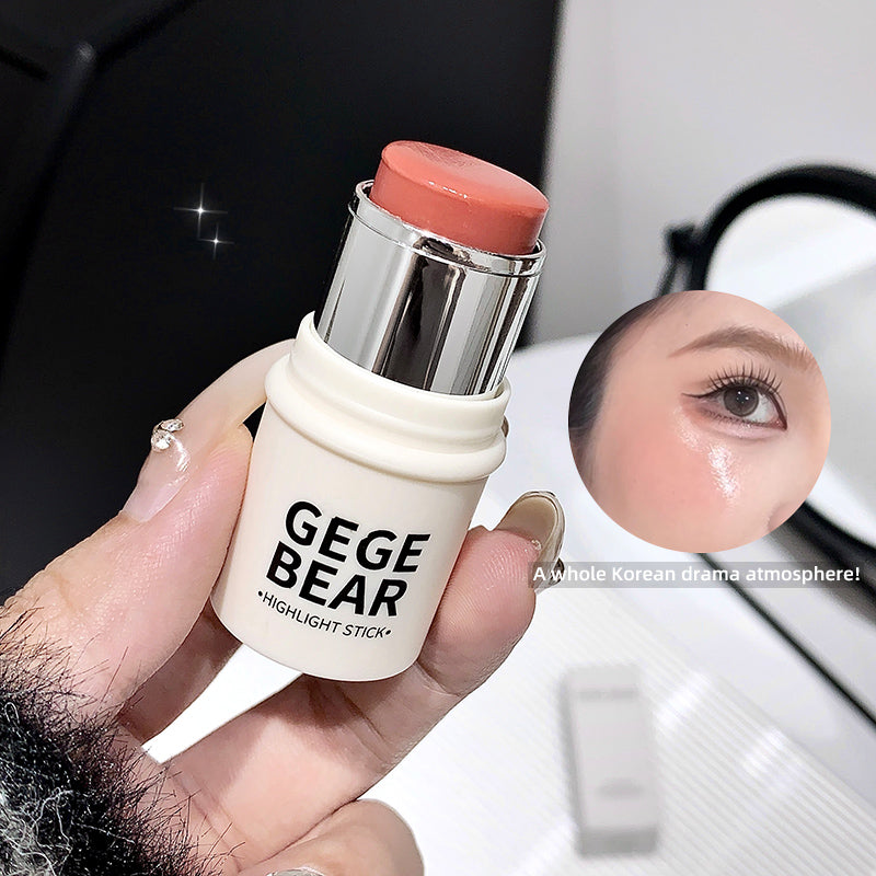 Hand holding a 'GEGE BEAR' highlight stick with a blurred background