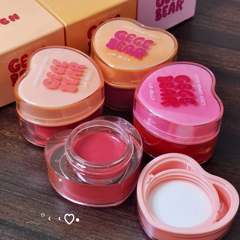 Heart-shaped lip jelly containers with 'Gee Bear' branding on a wooden surface.