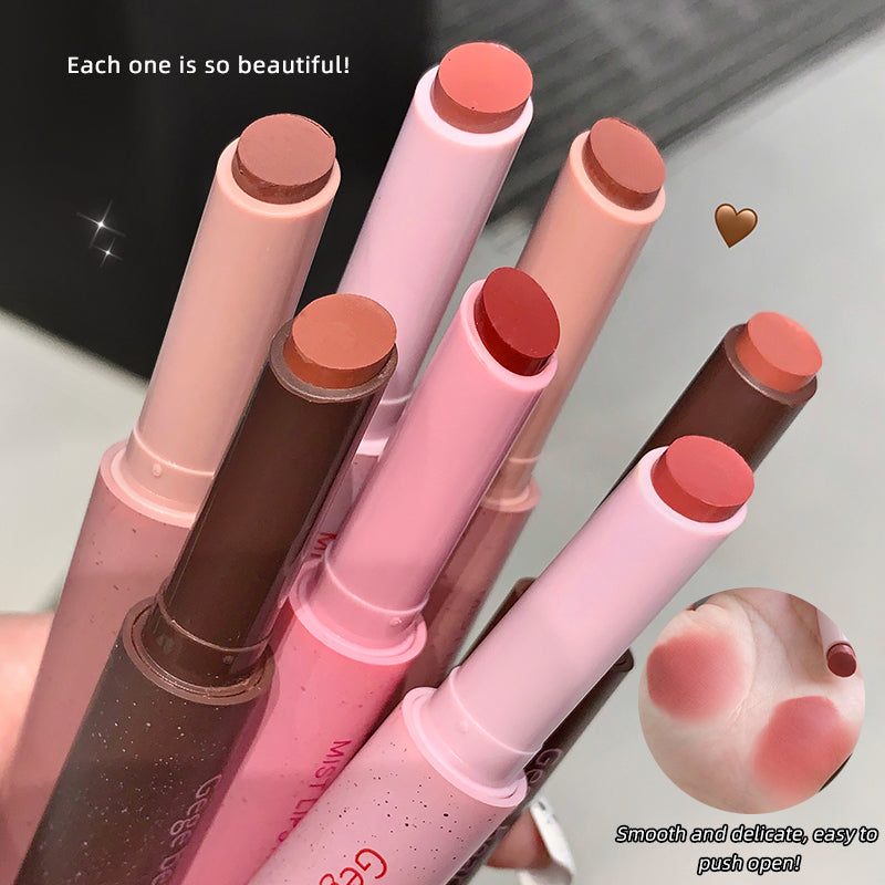 Set of lipsticks in various shades with a heart emoji and text on a neutral background