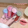 Set of lip glosses in clear cases held by a hand, with close-up of lips wearing pink gloss.