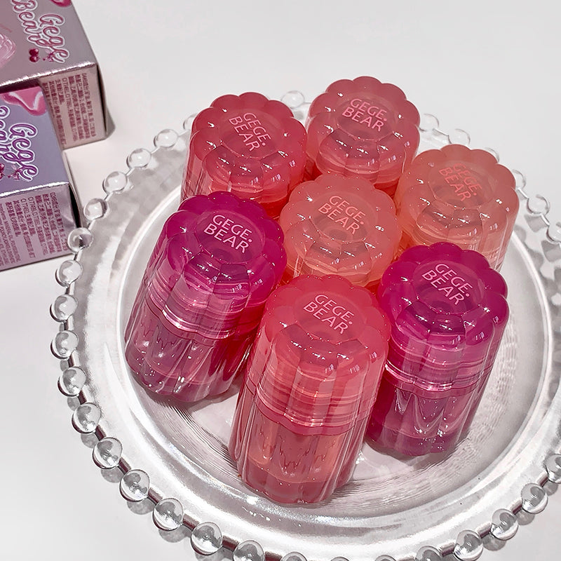 Pink and red GEGER BEAR products on a decorative plate with packaging in the background.