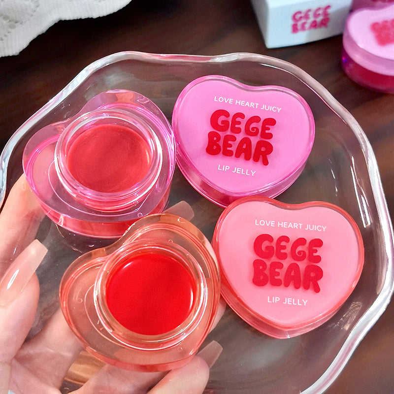 Heart-shaped GEGE BEAR lip jelly containers on a wooden surface
