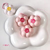 Pink 'Gege bear' products on a white cloud-shaped stand with a small pink keychain in the background.