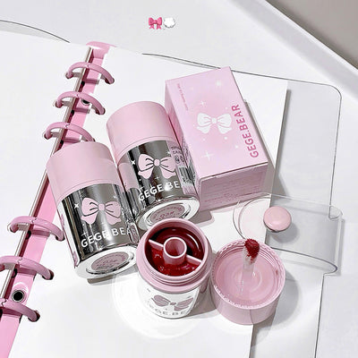 Pink and silver GEGER BEAR products including a water bottle, lip balm, and stationery items on a white surface.